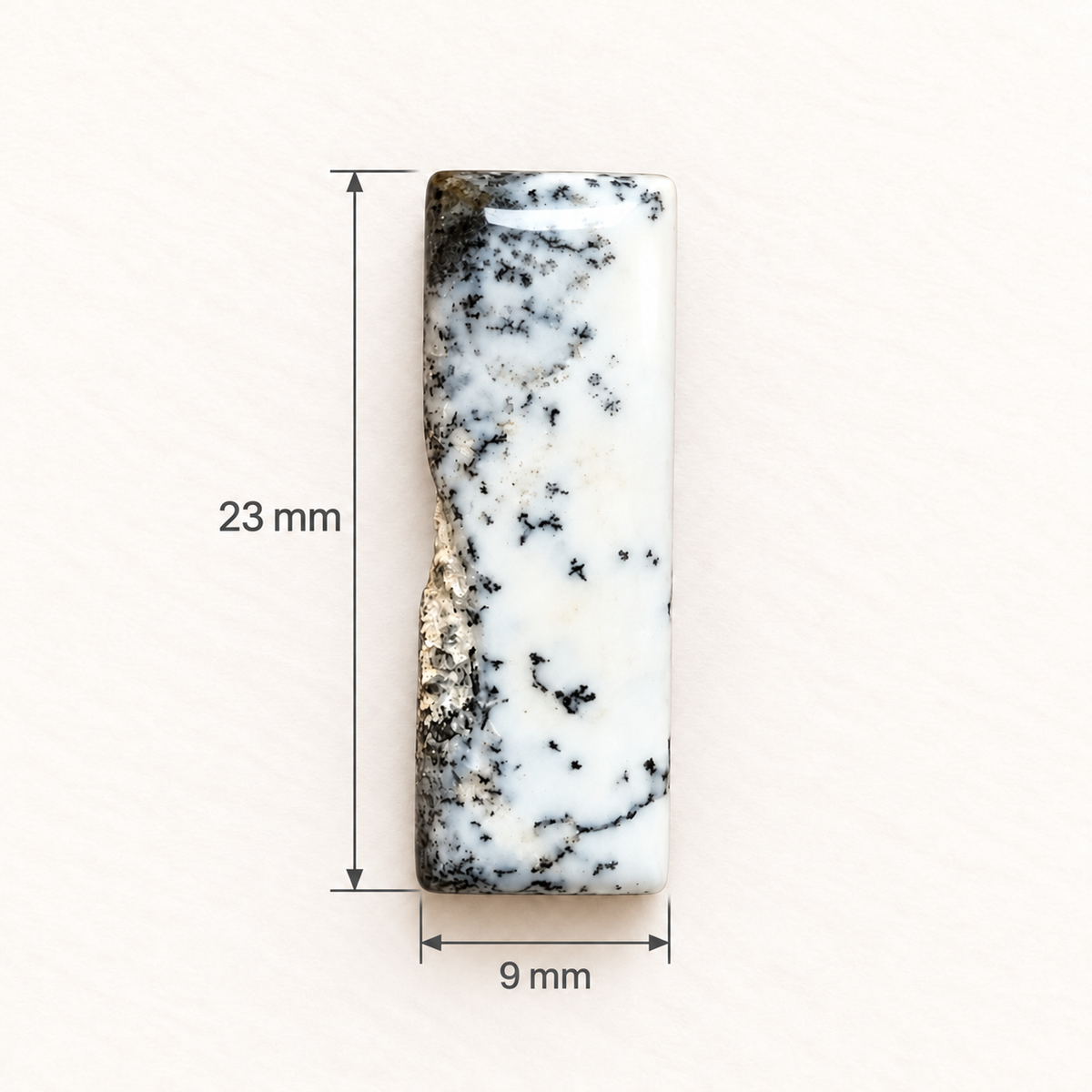 Dezelfde dendrietopaal cabochon met maataanduiding: 23 millimeter hoog en 9 millimeter breed